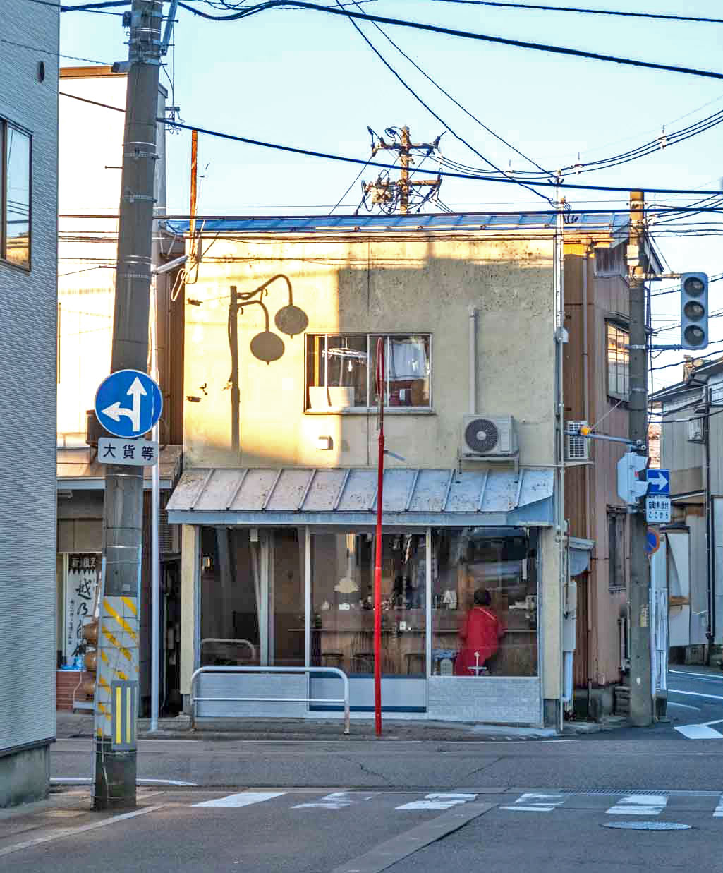 夕方の光に照らされた、三条市本町の角にあるアレトソレの外観